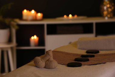 Spa salonunda masaj masasında bitkisel kompres ve taşlar