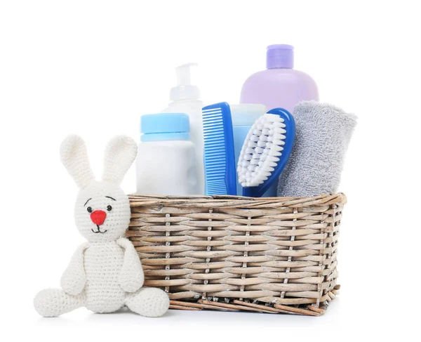 Wicker basket with baby cosmetic products and knitted rabbit isolated on white — 스톡 사진