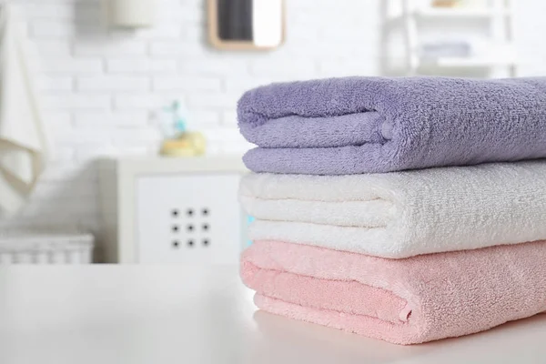 Montón de toallas frescas en la mesa en el baño, primer plano. Espacio para texto —  Fotos de Stock