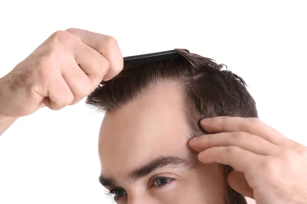 Young man with comb on white background, closeup. Hair loss problem — Stock Photo, Image