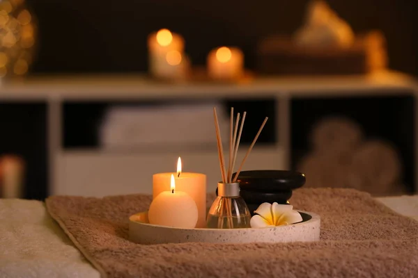 Burning candles and aromatic reed freshener on table in spa salon — Stock Photo, Image