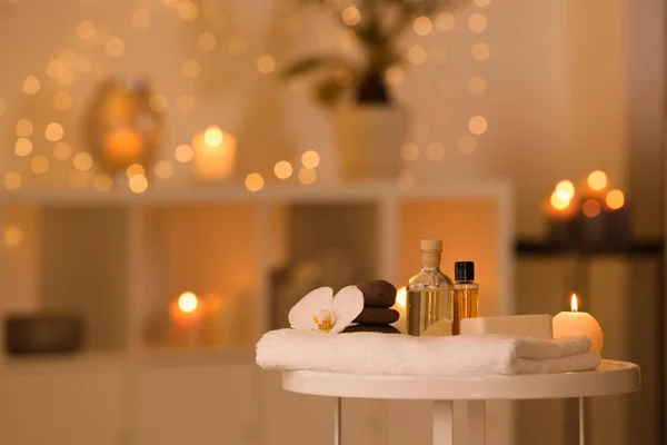 Wellnessbedarf, brennende Kerze und Blume auf dem Tisch im Schönheitssalon, Platz für Text — Stockfoto
