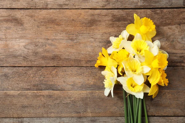 Ramillete de narcisos sobre fondo de madera, vista superior con espacio para texto. Flores frescas de primavera — Foto de Stock