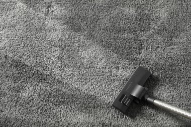 Elektrikli süpürge ile gri halıdan kir çıkarma, üst görünüm. Metin için alan