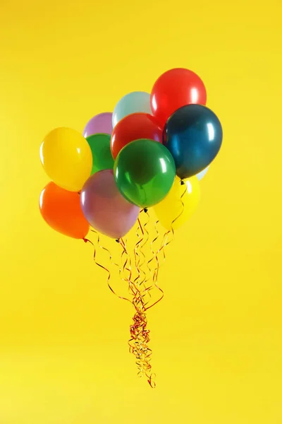 Bando de balões brilhantes no fundo da cor. Tempo de celebração — Fotografia de Stock