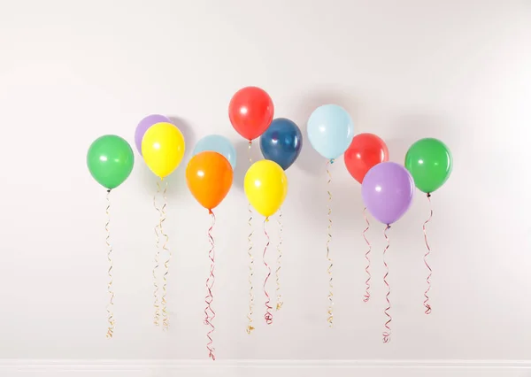 Işık duvarına karşı farklı parlak balonlar. Kutlama zamanı — Stok fotoğraf
