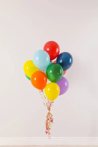 Un mucchio di palloncini luminosi contro la parete luminosa. Tempo di celebrazione — Foto Stock