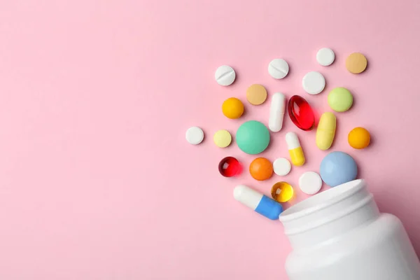 Botella con diferentes píldoras en el fondo de color, la puesta plana. Espacio para texto — Foto de Stock