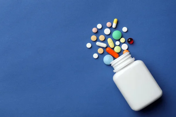 Flasche mit verschiedenen Pillen auf farbigem Hintergrund, flach liegend. Raum für Text — Stockfoto