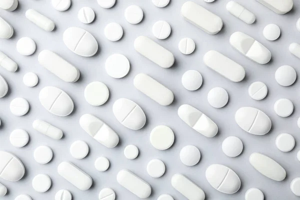Viele verschiedene Pillen auf grauem Hintergrund, flach liegend — Stockfoto