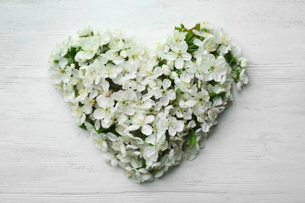 Heart made of beautiful fresh spring flowers on color background, top view — Stok Foto