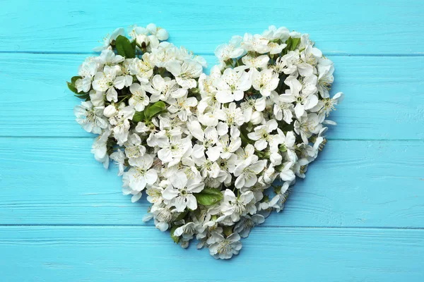 Serce wykonane z pięknych świeżych kwiatów wiosennych na kolorowym tle, widok z góry — Zdjęcie stockowe
