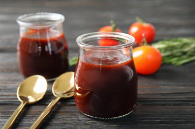 Ahşap masa üzerinde barbekü sosu ve kaşık cam kavanoz