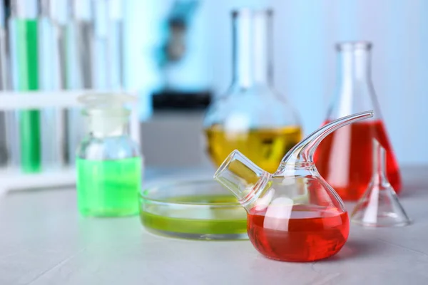 Vidraria de laboratório com amostras na mesa dentro de casa, espaço para texto. Química da solução — Fotografia de Stock