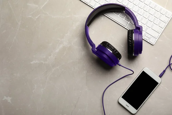 Platte lay compositie met koptelefoon, smartphone en toetsenbord op tafel. Ruimte voor tekst — Stockfoto