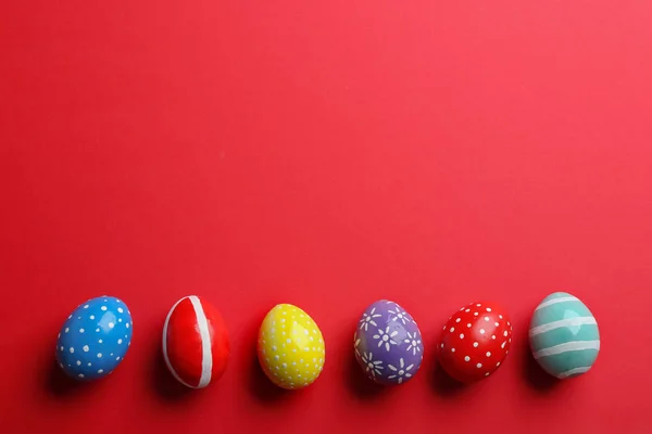 Composição de colocação plana de ovos de Páscoa pintados sobre fundo de cor, espaço para texto — Fotografia de Stock
