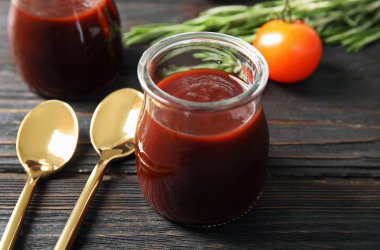 Ahşap masa üzerinde barbekü sosu ve kaşık cam kavanoz