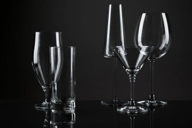 Koyu arka planda farklı içecekler için boş bardaklar