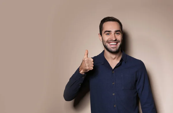 Man showing THUMB UP gesture in sign language on color background, space for text — Stock Photo, Image