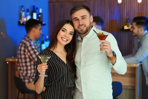 Jovem casal com coquetéis martini na festa — Fotografia de Stock