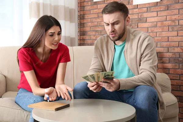 Ένα δυστυχισμένο νεαρό ζευγάρι με λεφτά στο σπίτι. Οικονομικά προβλήματα — Φωτογραφία Αρχείου