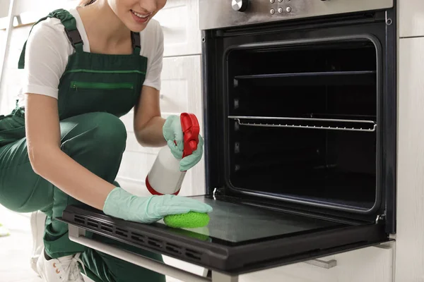 Professzionális gondnok takarítás sütő szivaccsal a konyhában, Vértes — Stock Fotó