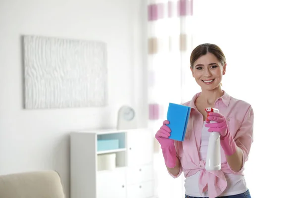 Gelukkige vrouw in handschoenen met reinigingsproduct en spons thuis. Ruimte voor tekst — Stockfoto