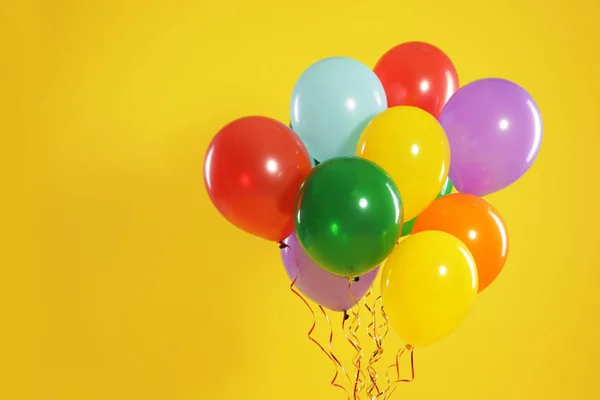 Bando de balões brilhantes sobre fundo de cor, espaço para texto. Tempo de celebração — Fotografia de Stock