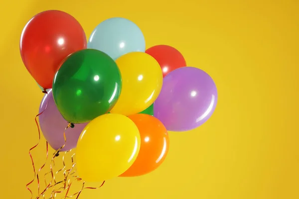 Bando de balões brilhantes sobre fundo de cor, espaço para texto. Tempo de celebração — Fotografia de Stock