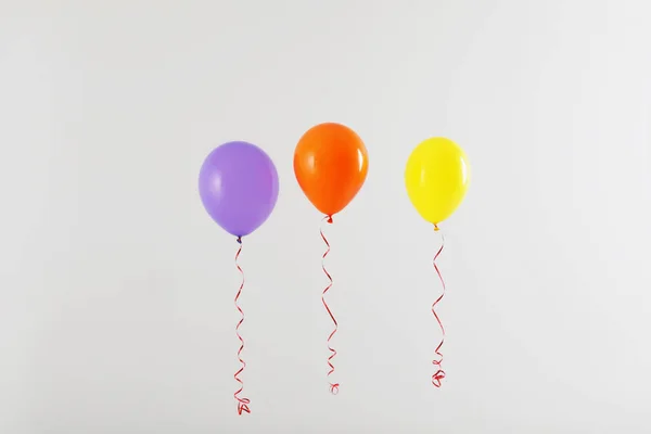 Diferentes globos brillantes sobre fondo claro. Tiempo de celebración — Foto de Stock