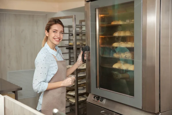 Bella donna al forno nel laboratorio di panetteria — Foto Stock
