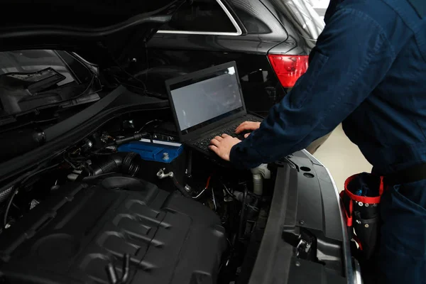 Técnico verificando carro com laptop na oficina de reparação de automóveis, close-up — Fotografia de Stock