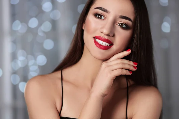 Mooie vrouw met stijlvolle nagellak tegen vervaagde lichten — Stockfoto