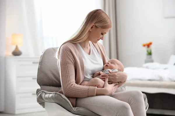Ibu dengan bayi kecilnya duduk di kursi di rumah — Stok Foto