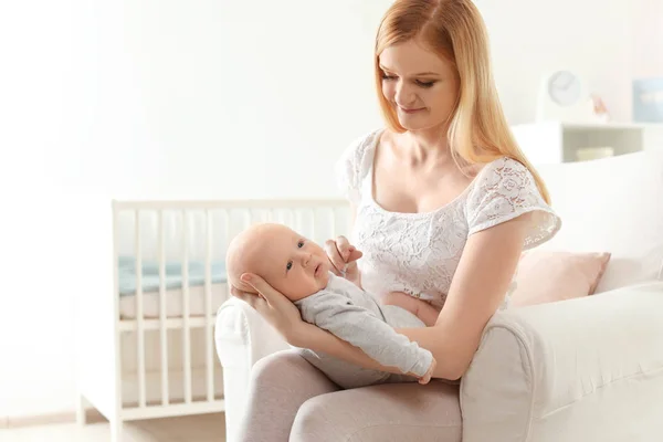 Glückliche Mutter mit ihrem Baby im Sessel zu Hause — Stockfoto