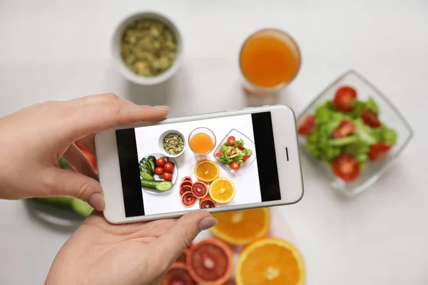 Gros plan du blogueur alimentaire photographiant des fruits et légumes frais avec téléphone portable, vue de dessus — Photo
