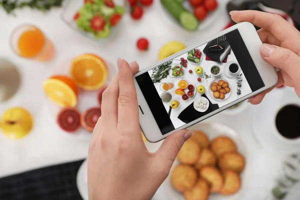 Closeup az élelmiszer-blogger fényképezés ízletes reggeli mobil telefon, felülnézet — Stock Fotó