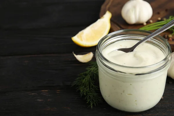 Composizione con vasetto di salsa all'aglio su tavolo di legno. Spazio per testo — Foto Stock