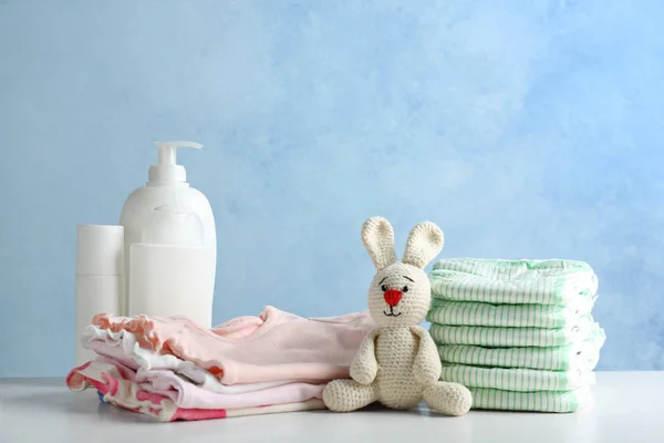 Stapel luiers en baby accessoires op tafel tegen achtergrondkleur. Ruimte voor tekst — Stockfoto