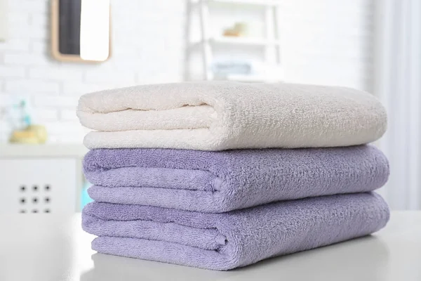 Bunt med fräscha handdukar på bordet i badrum, närbild — Stockfoto