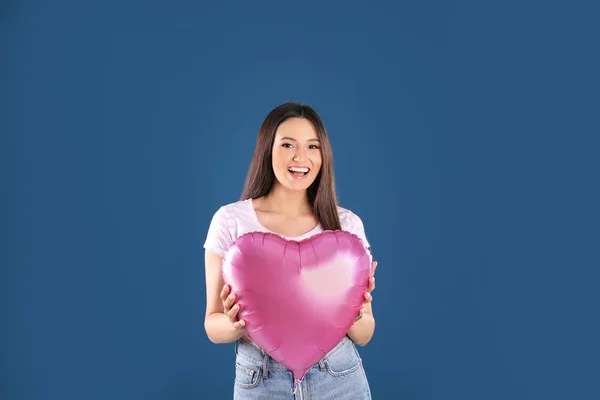 Portret van jonge vrouw met hartvormige ballon op kleur achtergrond — Stockfoto