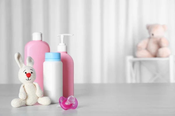 Baby accessoires en speelgoed op tafel tegen lichte achtergrond. Ruimte voor tekst — Stockfoto