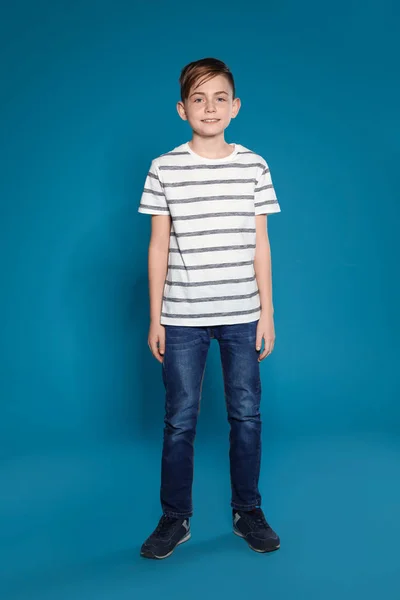 Full längd porträtt av söt pojke på färg bakgrund — Stockfoto