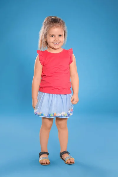 Portrét roztomilej holčičky proti barevnému pozadí — Stock fotografie