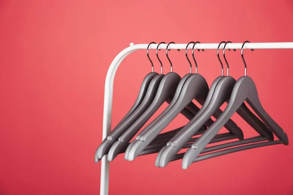 Cabides de roupas vazias em rack de metal contra fundo de cor. Espaço para texto — Fotografia de Stock