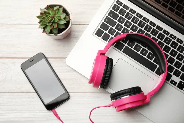 Composição de leigos planos com fones de ouvido, laptop e smartphone na mesa — Fotografia de Stock