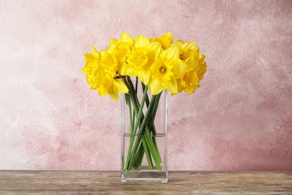 Ramillete de narcisos en jarrón sobre mesa sobre fondo de color. Flores frescas de primavera —  Fotos de Stock