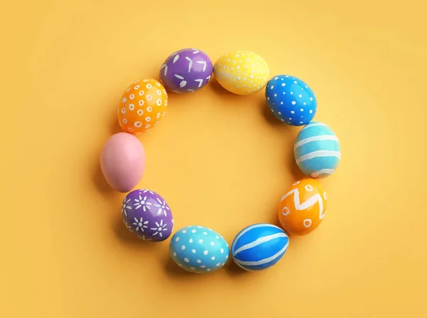 Cadre fait d'œufs de Pâques peints sur fond de couleur, vue de dessus. Espace pour le texte — Photo
