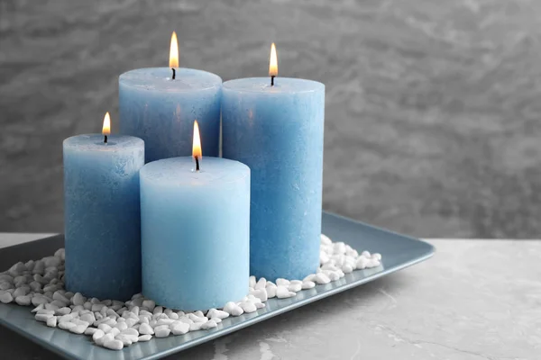 Placa con velas encendidas y rocas sobre la mesa, espacio para texto —  Fotos de Stock