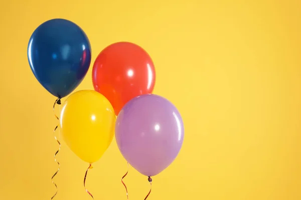 Heldere ballonnen op kleur achtergrond, ruimte voor tekst. De tijd van de viering — Stockfoto